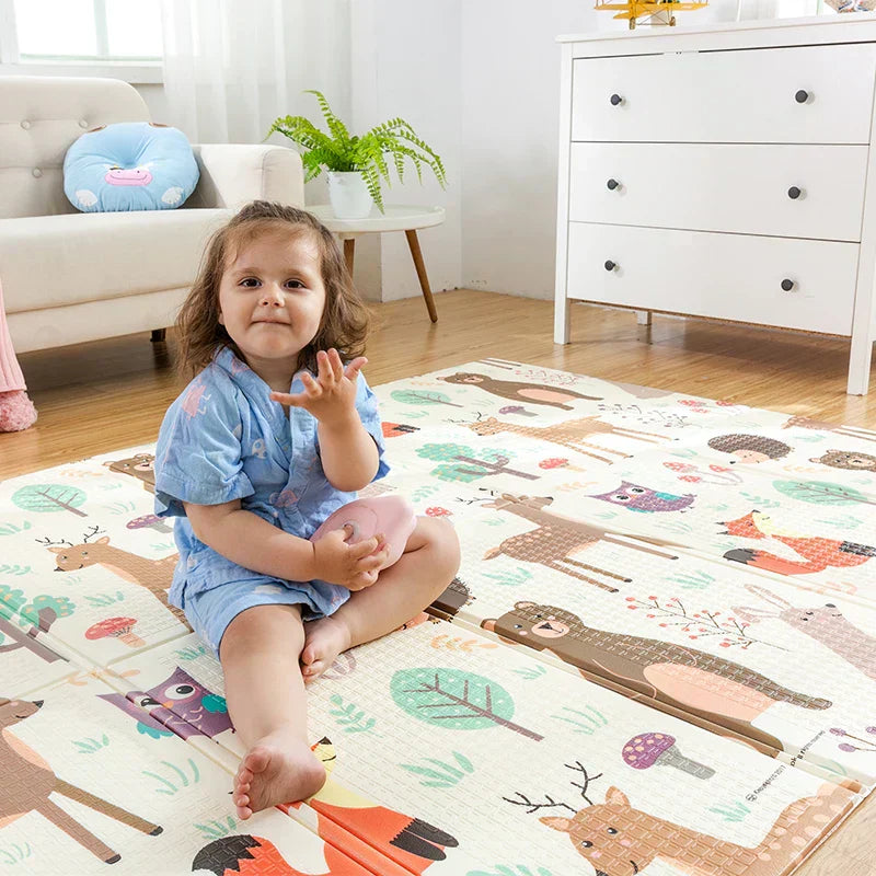 fetita care se joaca pe covorasul de joaca