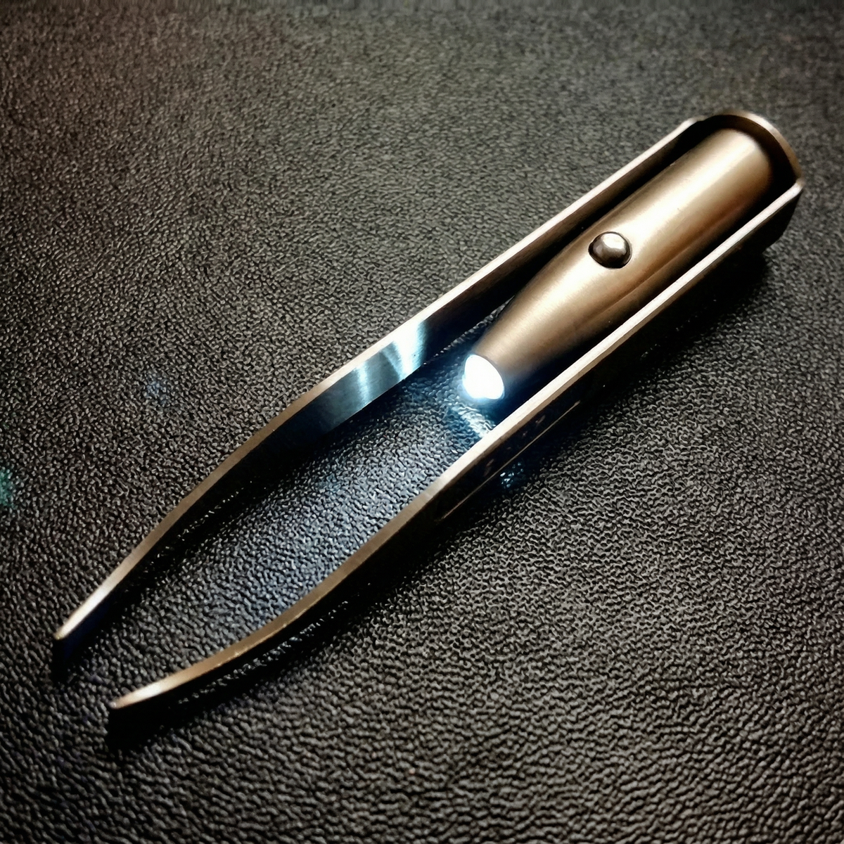 Pensetă cu LED aprins, pe fundal negru