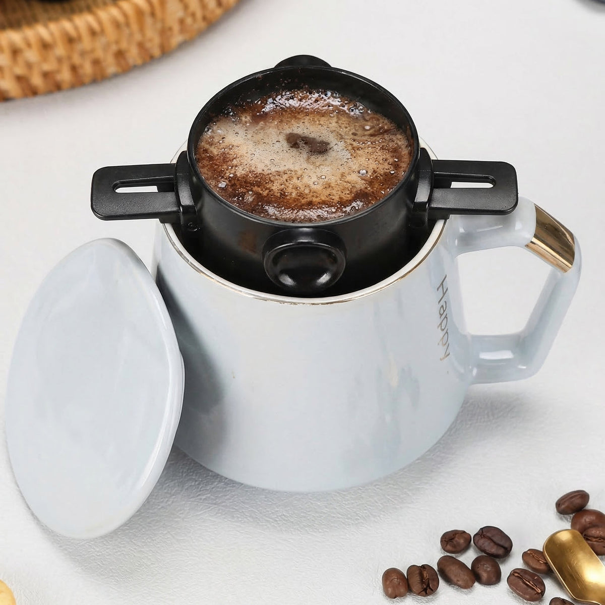 Filtrul de cafea așezat pe o cană albă, cu cafea în el