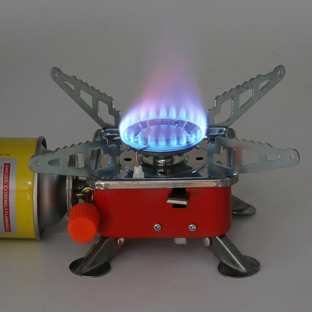Aragazul aprins, cu flacăra albastră, conectat la o butelie de gaz tip cartuș