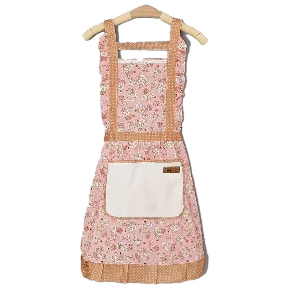 Șorț de bucătărie floral roz cu dantelă, volane și buzunar crem, pe umeraș, pe fundal alb