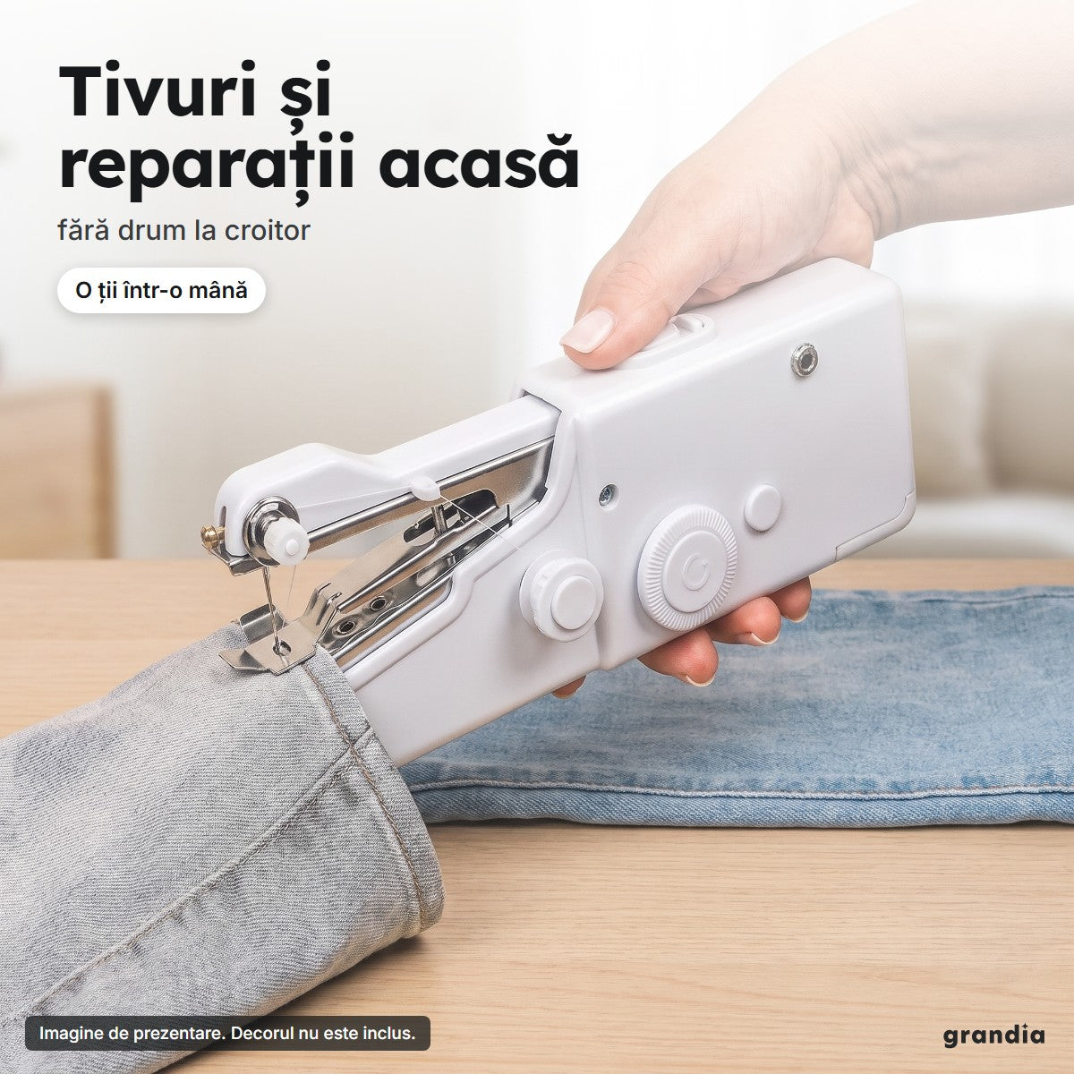 Mână care coase tivul unor blugi cu mașina de cusut portabilă, pe o masă