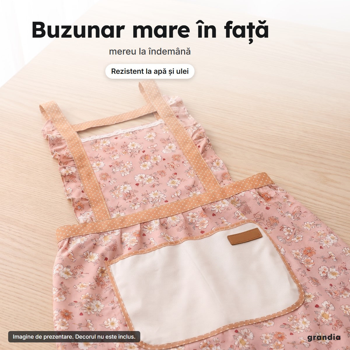 Buzunarul mare crem și volanul cu buline de la tivul șorțului floral roz, văzute de aproape